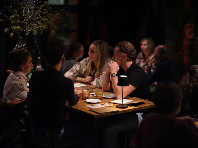 Vrienden aan tafel tijdens een avond bij DIELS